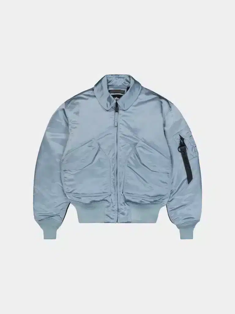 A light blue bomber jacket with a front zipper, large side pockets, ribbed cuffs and hem, and an arm pocket with a black tag.