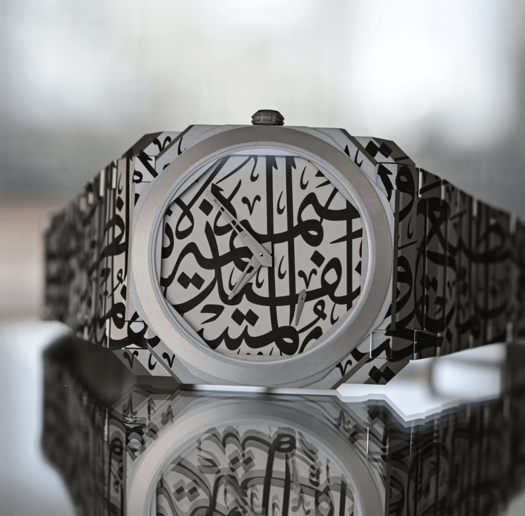 Close-up of a luxury Bvlgari Octo Finissimo wristwatch with an Arabic calligraphy design on the dial and bracelet, reflected on a glossy surface.