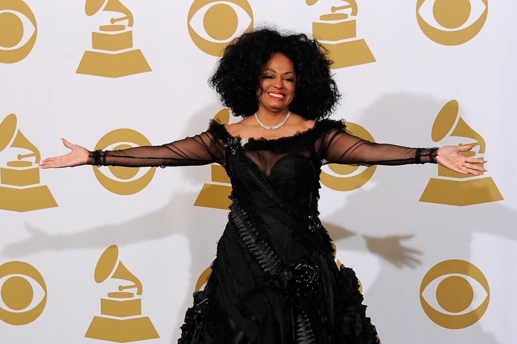 Diana Ross and Seal in a black dress with sheer sleeves smiling and posing with arms outstretched in front of a backdrop featuring Grammy Award and CBS logos.