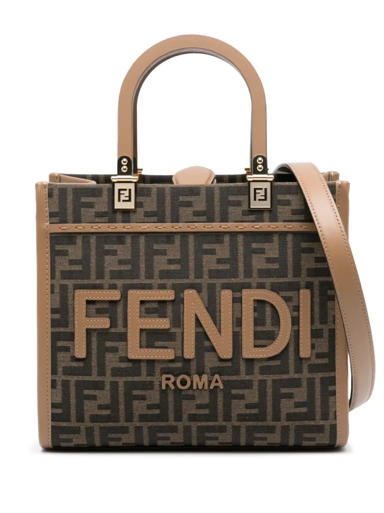 The History of Fendi: A Fendi tote bag with a monogram design in brown and tan tones, featuring the large 'Fendi Roma' logo on the front, and decorated with tan leather handles and trim.