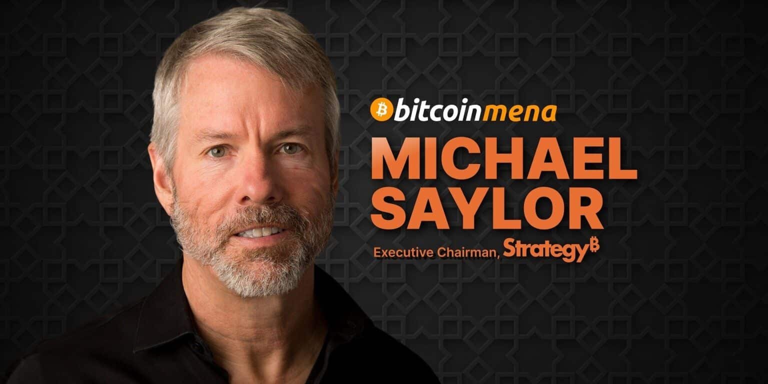 Close-up of a man with gray hair and a beard, wearing a black shirt, with the text "bitcoin mena, Michael Saylor, Executive Chairman, STrategy" on a patterned dark background.