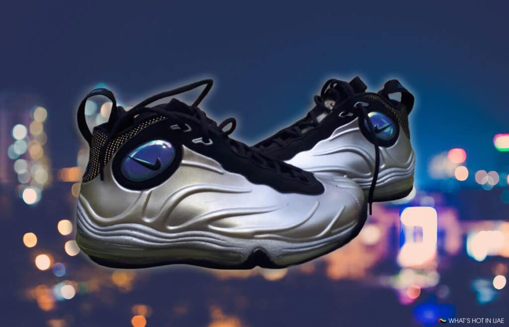 Nike Total Foamposite Max Retro (2026): A pair of sleek, metallic-colored sneakers with a shiny black logo on the side against a blurred urban night background.