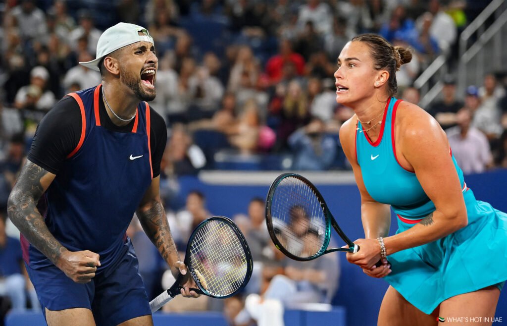 Two tennis players on a court expressing intense emotions; the male player is shouting with fist clenched, wearing a navy sleeveless shirt, while the female player is focused, poised with racquet in hand, dressed in a turquoise outfit.
