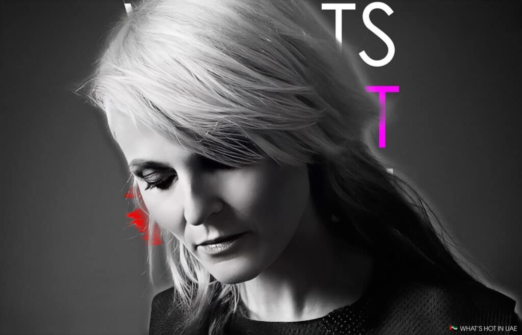 A monochrome portrait of a person with light-colored hair looking downward, featuring red and colorful text elements in the background.