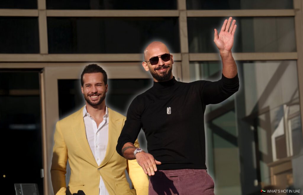 Andrew Tate vs Chase DeMoor: Andrew and tristan Tate in a casual setting; one is waving and wearing sunglasses with a black shirt, while the other wears a yellow blazer and smiles at the camera.
