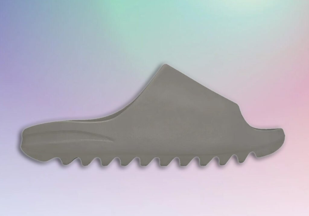 A gray slipper with a minimalist design and a jagged sole, set against a pastel gradient background.