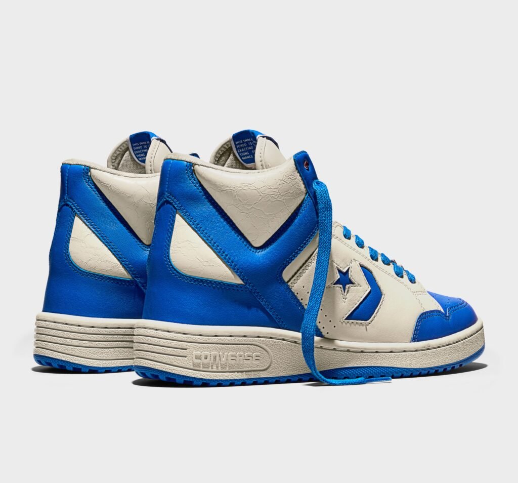 Blue and white high-top sneakers with the Converse logo on the side and sole, featuring a classic design with matching blue laces.