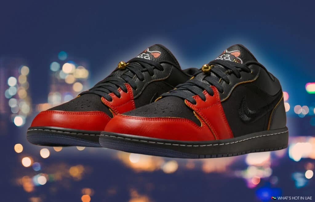 Black and red sneakers with a unique logo on the tongue, set against a blurred city lights background.