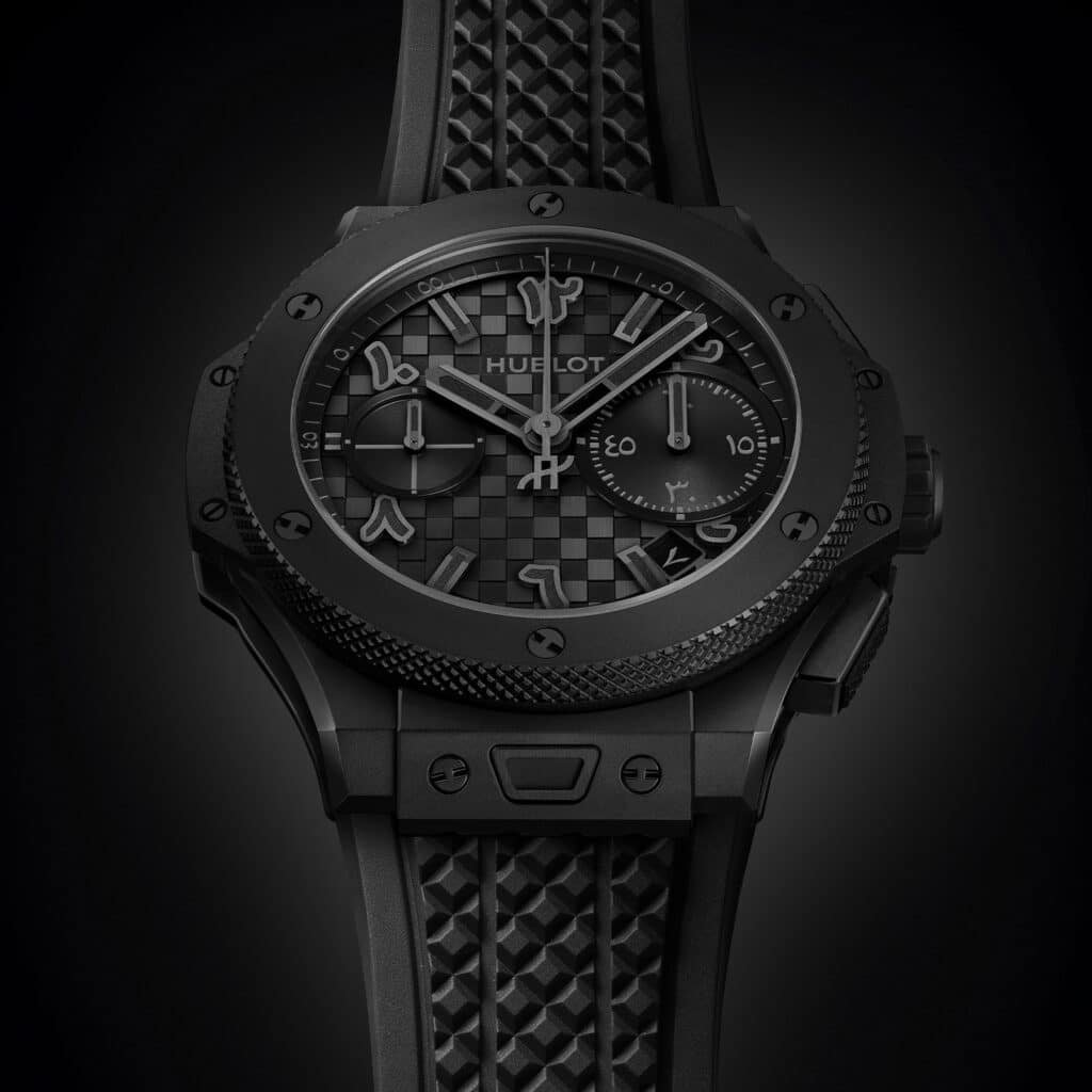 A luxury black Hublot Big Bang Dubai wristwatch featuring a textured dial with Arabic numerals, sub-dials, and a black rubber strap.
