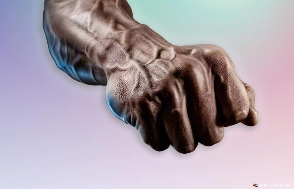 A muscular arm with pronounced veins making a fist against a gradient background.