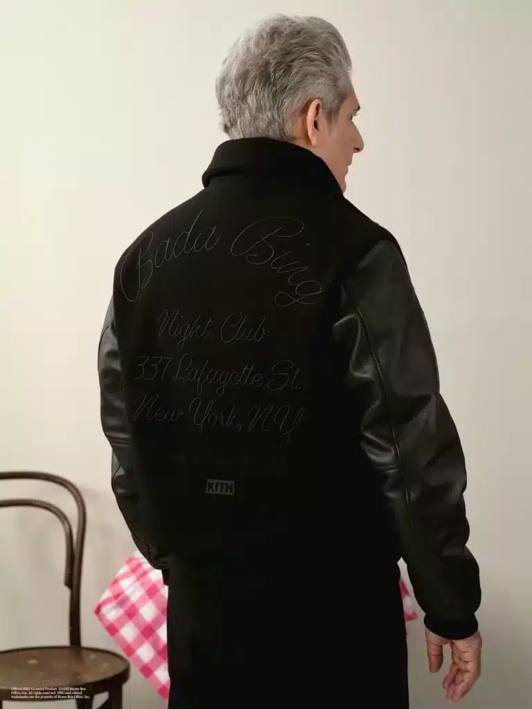A person with gray hair is wearing a black and leather jacket with "Bada Bing Night Club" and a New York address embroidered on the back.