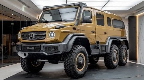 A large, rugged yellow Mercedes-Benz Unimog off-road vehicle with six wheels and heavy-duty tires, displayed in a modern showroom.