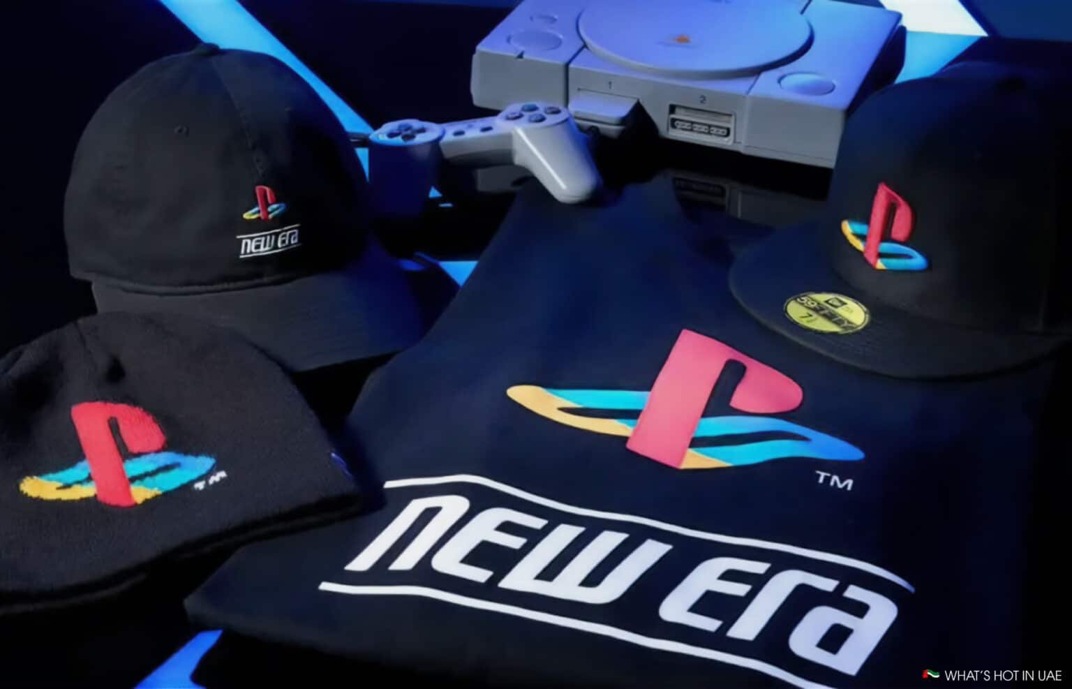 Clothing and accessories displaying PlayStation and New Era logos, with a classic game console and controller in the background.