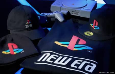 Clothing and accessories displaying PlayStation and New Era logos, with a classic game console and controller in the background.