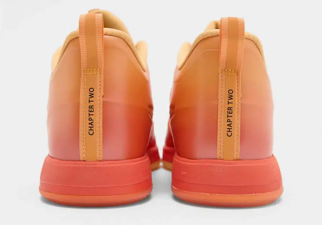 The back view of orange sneakers with the text "CHAPTER TWO" on the heel tabs.