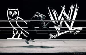 Two wrestlers in mid-action in a ring, with a stylized owl and "W" logo in the background.