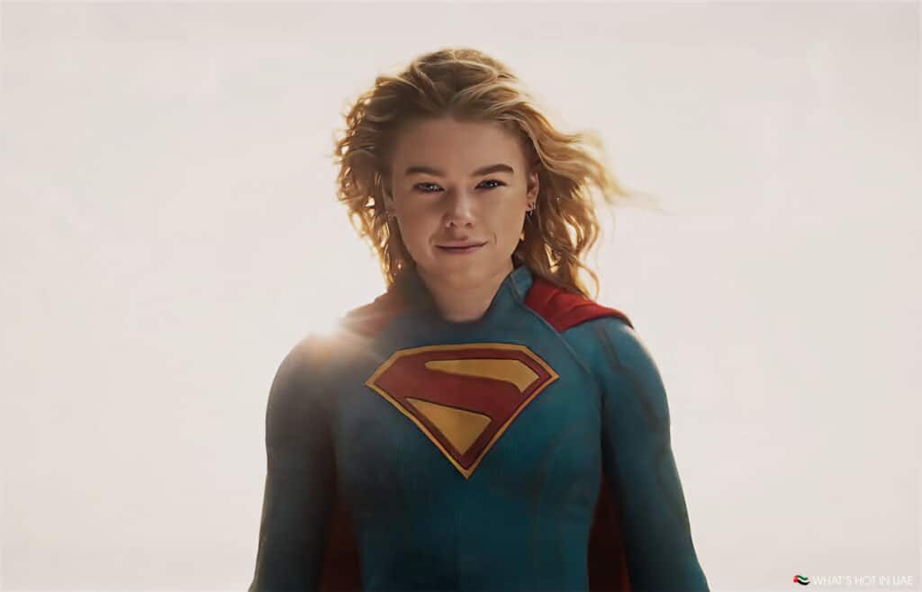 A person in a superhero costume with a red and yellow 'S' emblem on their chest, wearing a red cape, against a bright background.