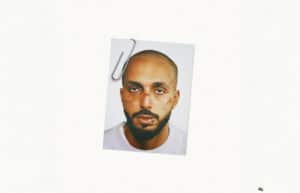 A photo of a man with a neutral expression, clipped to a white background.