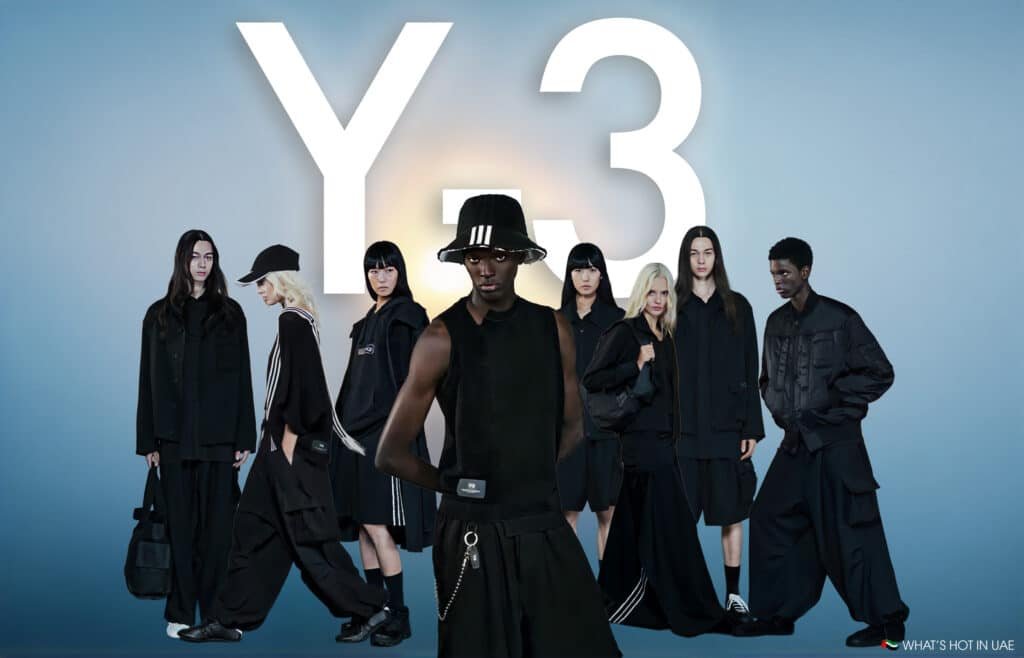 A group of models wearing black Y-3 clothing, standing and posing against a light gradient background with the large white text 'Y-3' in the center.