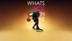A basketball player dribbles in front of text saying "What's Hot in UAE," with a partial UAE flag design.