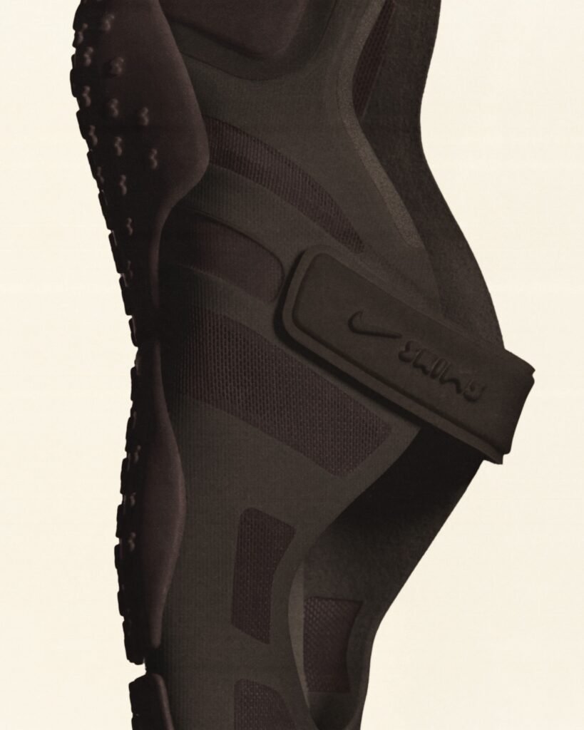 Close-up of a black or dark-colored NikeSKIMS Rift Mesh shoe showcasing textured sole, mesh upper, and a strap with subtle branding.