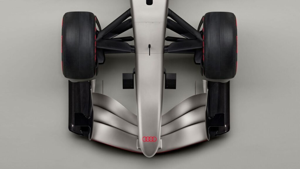 Top view of a Formula 1 car featuring prominent tires, aerodynamic design, and an Audi logo on the nose.