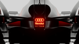 Rear view of a sleek Formula 1 car displaying the logos "Revolut" and "F1 Team" with an illuminated red logo above.