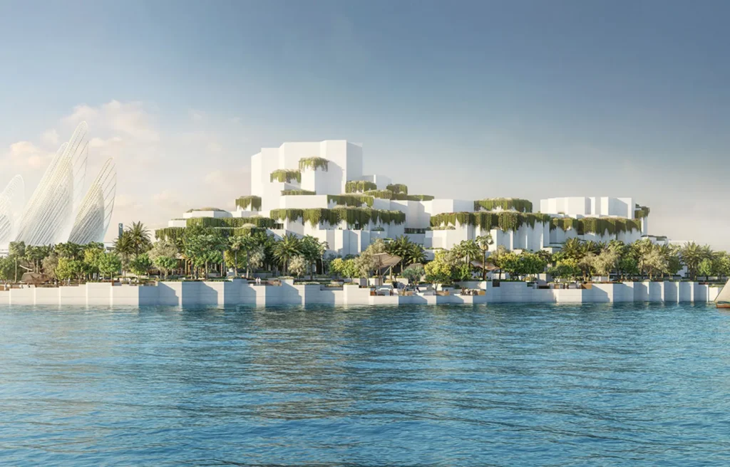 A modern, white architectural complex with greenery, set along a waterfront under a clear blue sky.