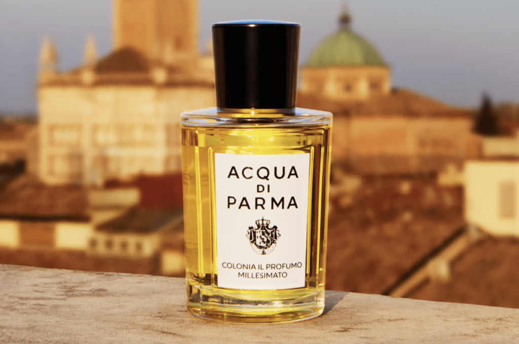 A bottle of Acqua di Parma Colonia Il Profumo Millesimato with an urban backdrop at sunset.