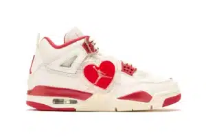 A white and red sneaker with a clear heart-shaped tag featuring a silhouette logo.