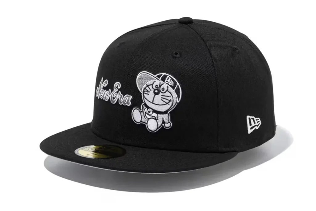 A black cap featuring an embroidered cartoon cat wearing a cap and the words "New Era" in white.