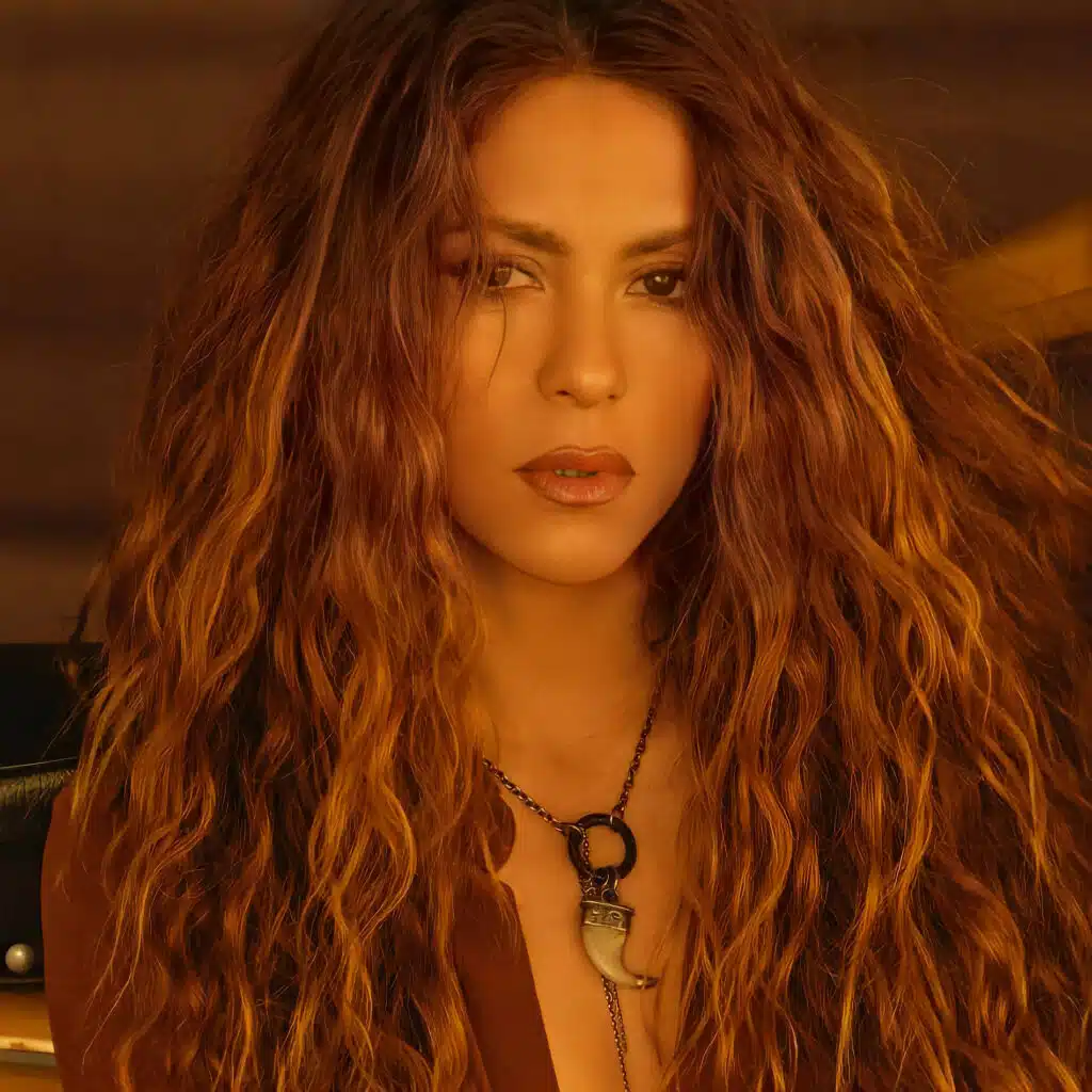 Global Superstar Shakira OFFLIMITS Music Festival with long, wavy auburn hair, wearing a necklace and a brown top, looking directly at the camera.