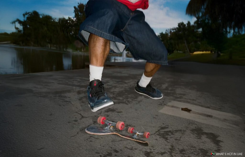 Person in mid-air performing a skateboard trick on a wet pavement.