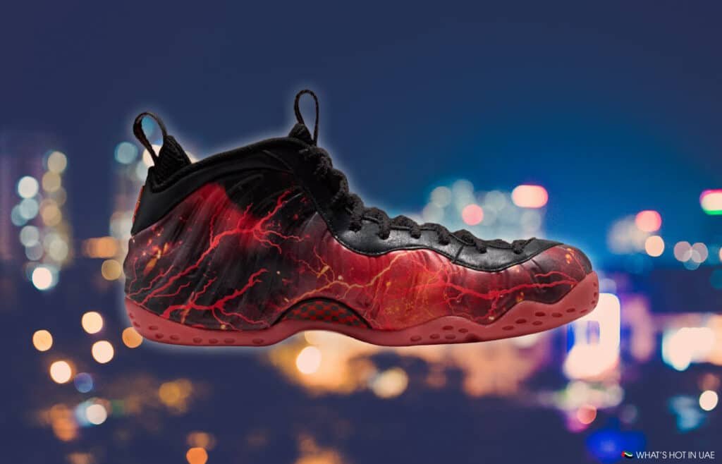 A Stranger Things Air Foamposite sneaker with a black and red lightning design on the side, set against a blurred cityscape background.