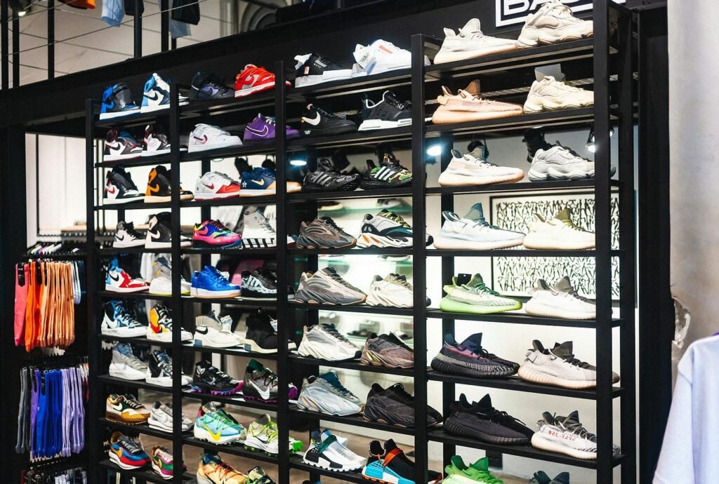 Display of various colorful sneakers on black shelves in a shoe store.