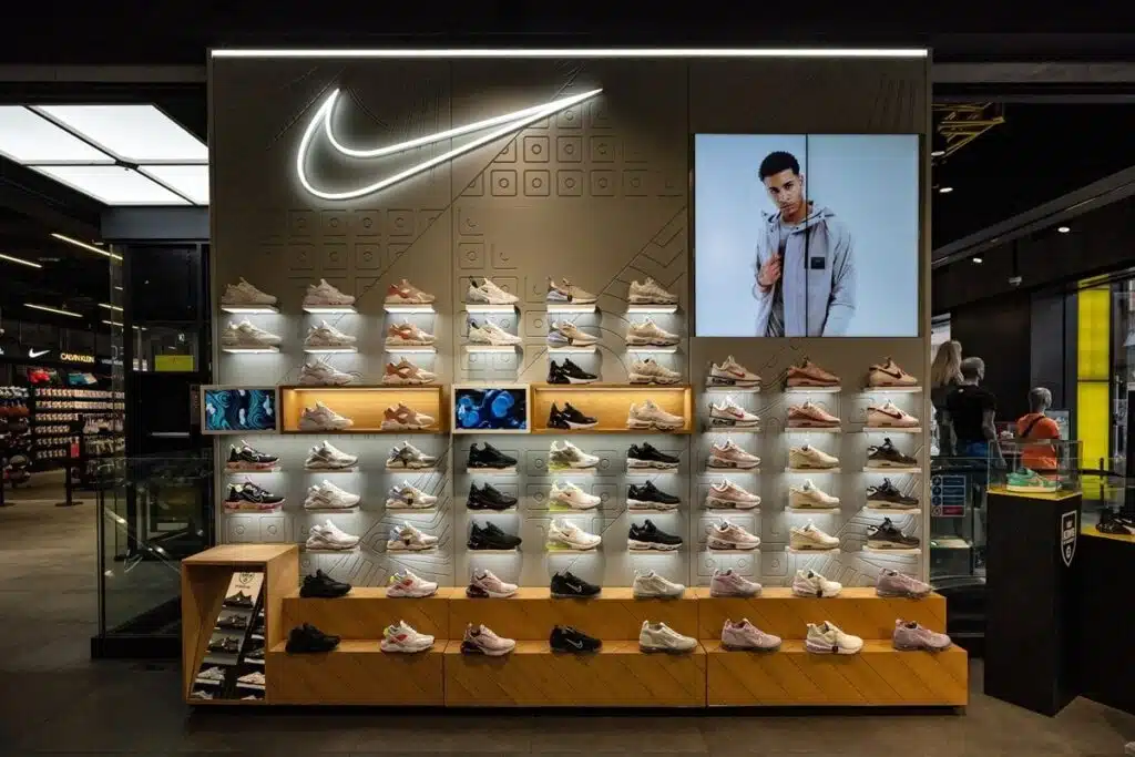 Nike sneaker wall with footwear, illuminated branding and a digital display