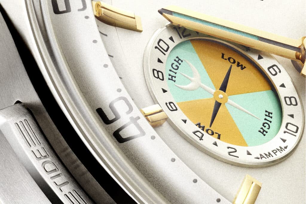 Close-up of a luxury watch face featuring a tide indicator with sections labeled "Low" and "High," and gold and silver details.