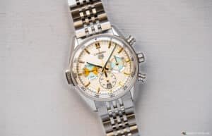 A luxury wristwatch with a stainless steel band and a beige dial featuring multiple subdials and hour markers.