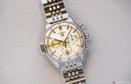 A luxury wristwatch with a stainless steel band and a beige dial featuring multiple subdials and hour markers.