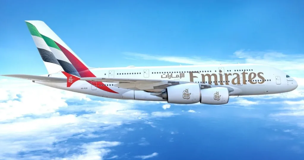 Emirates wide-body aircraft flying above the clouds, showing the airline’s branding and long-haul fleet in mid-air.