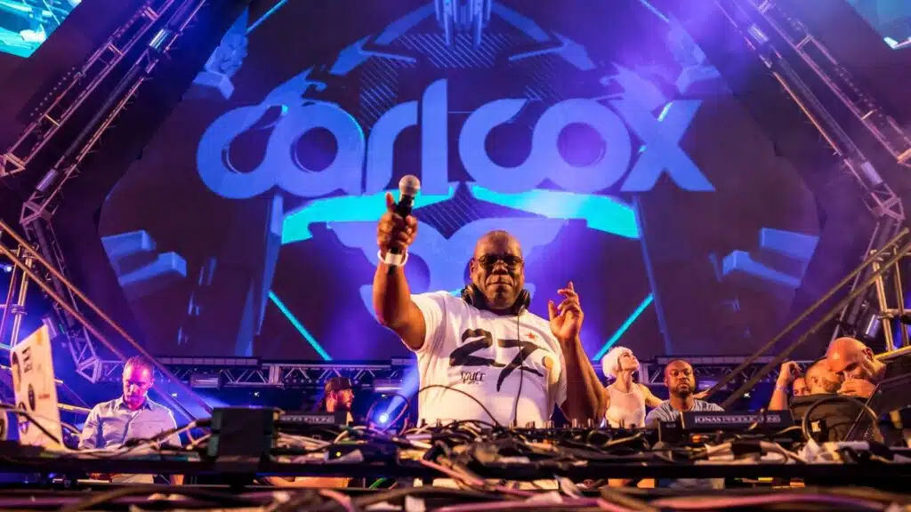 Dubai Nightlife Statistics 2026: Carl Cox is performing energetically on stage with a large crowd and a screen displaying vibrant visuals behind him.