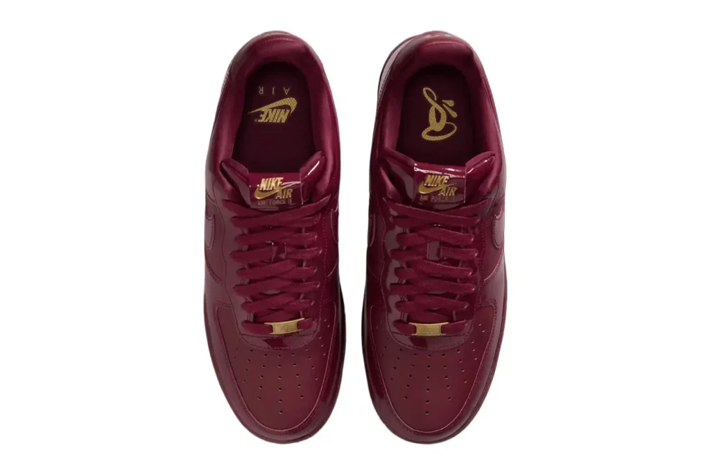 Pair of Nike Air Force 1 Low 'Dark Beetroot' sneakers viewed from above, featuring gold accents and logos on the insole and tongue.
