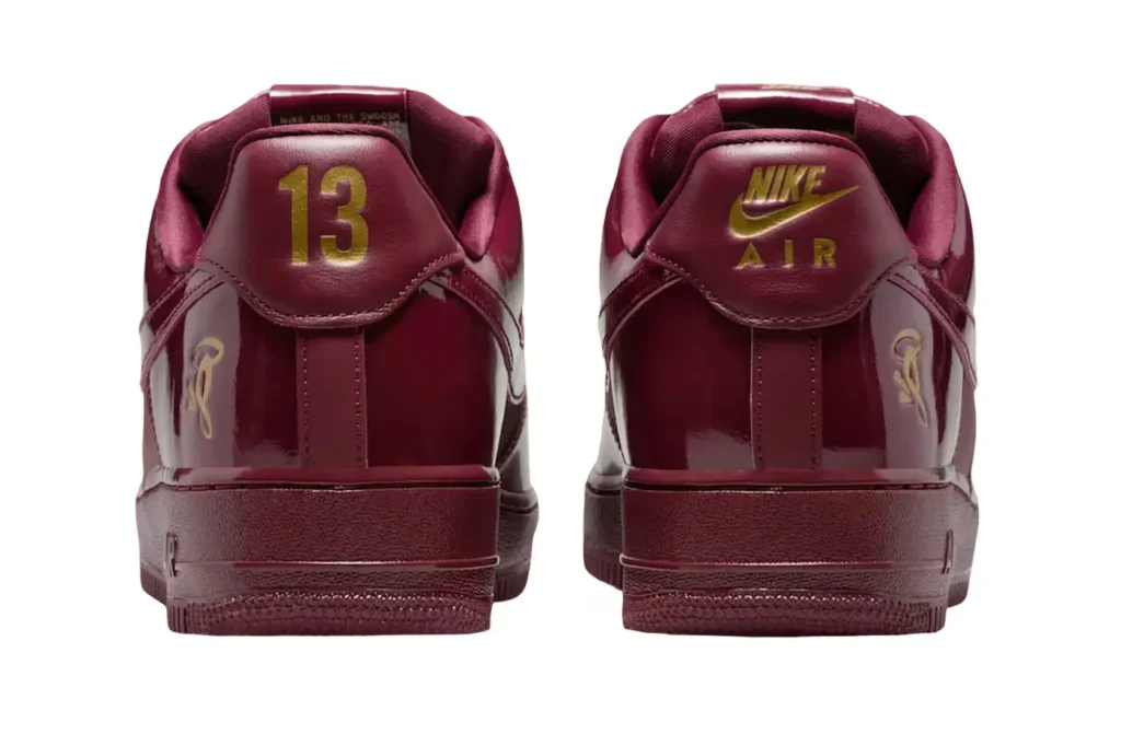 Two maroon Nike sneakers with gold details, including the number 13 and Nike Air branding on the heels.