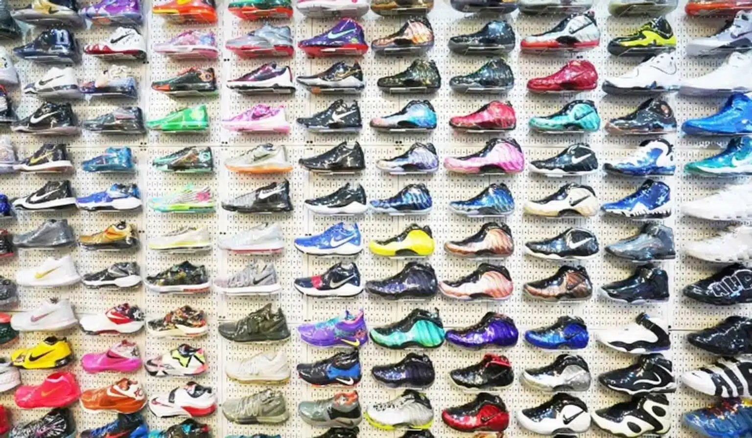 A wall display of colorful athletic shoes arranged neatly in rows.