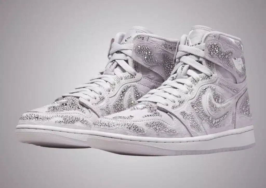 A pair of white Swarovski x Air Jordan 1 high-top sneakers embellished with sparkling rhinestones.