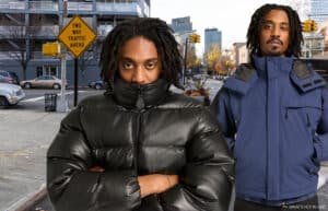 Two men with dreadlocks wear winter coats, standing on a city street with a "Two Way Traffic Ahead" sign.