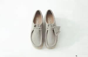 A pair of light gray suede desert boots with laces, displayed on a white background.