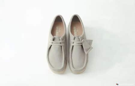 A pair of light gray suede desert boots with laces, displayed on a white background.