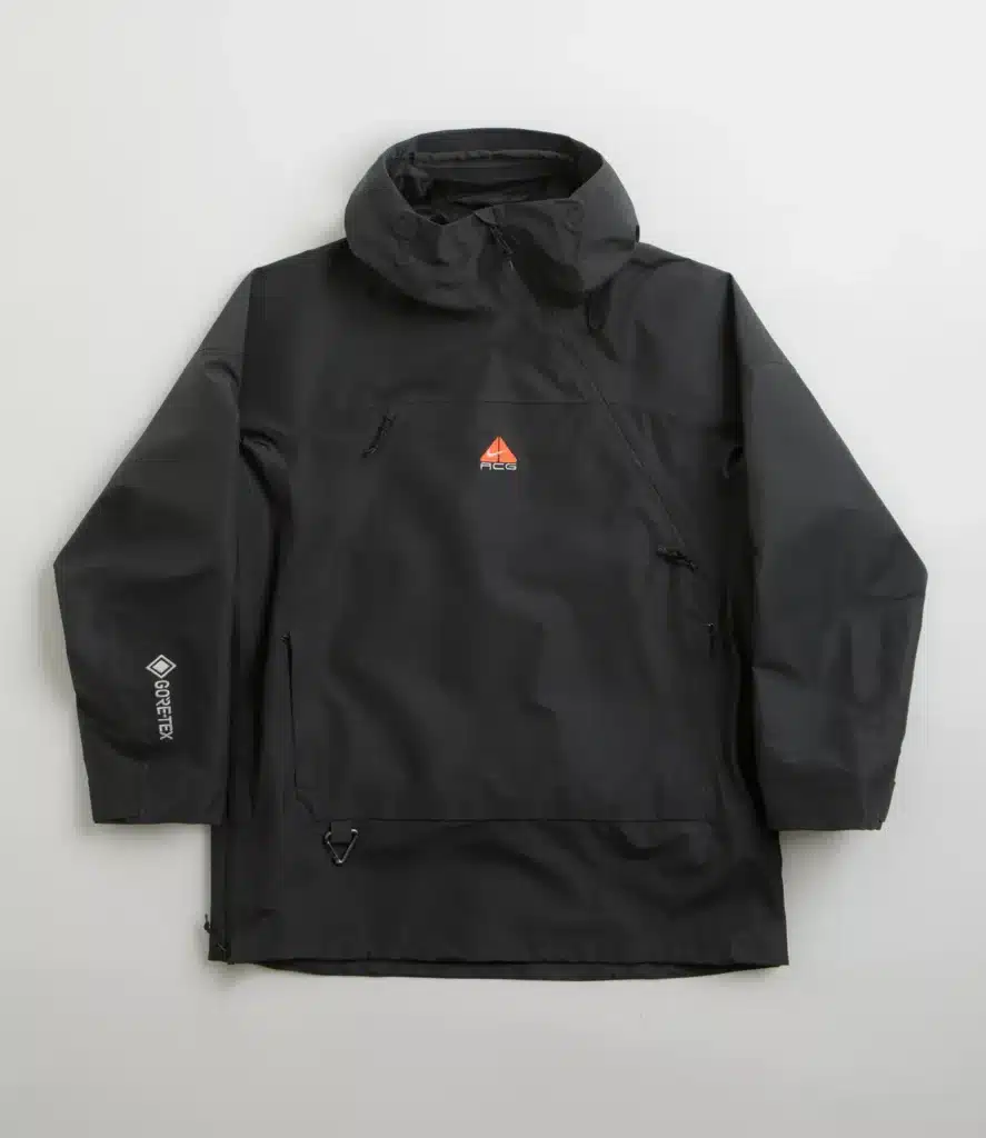 Black Gore-Tex jacket with a hood, featuring a small red triangular logo on the chest and white text on the sleeve.
