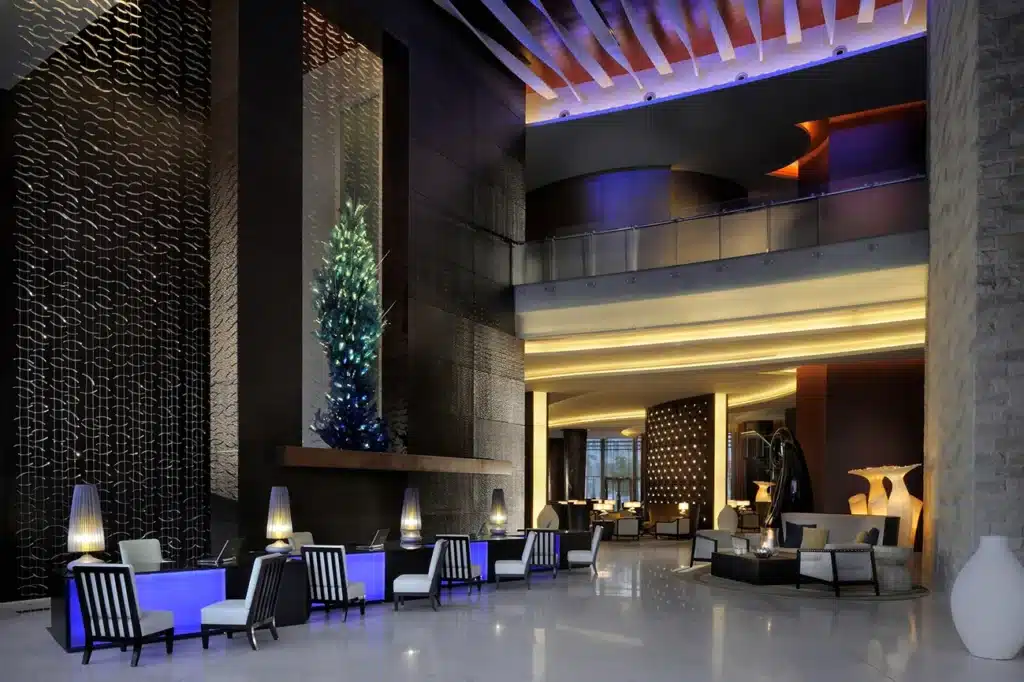 Modern Address Hotel Dubai Mall lobby with sleek furniture, ambient lighting, and a large, artistic installation on the wall.